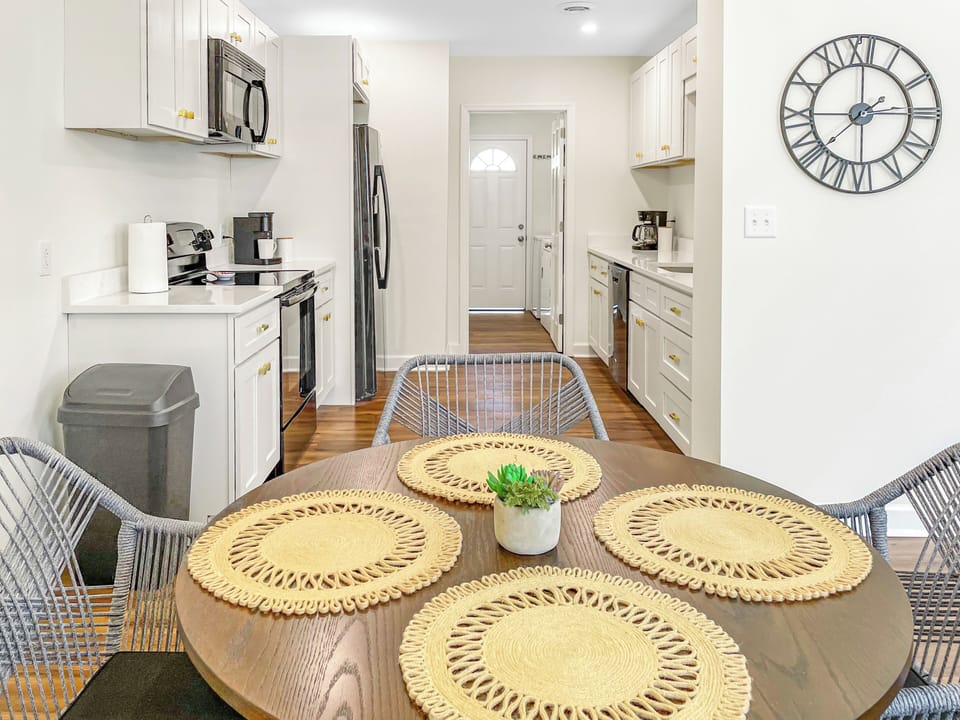 Dining area looking into full sized kitchen, with laundry room at the end and ha