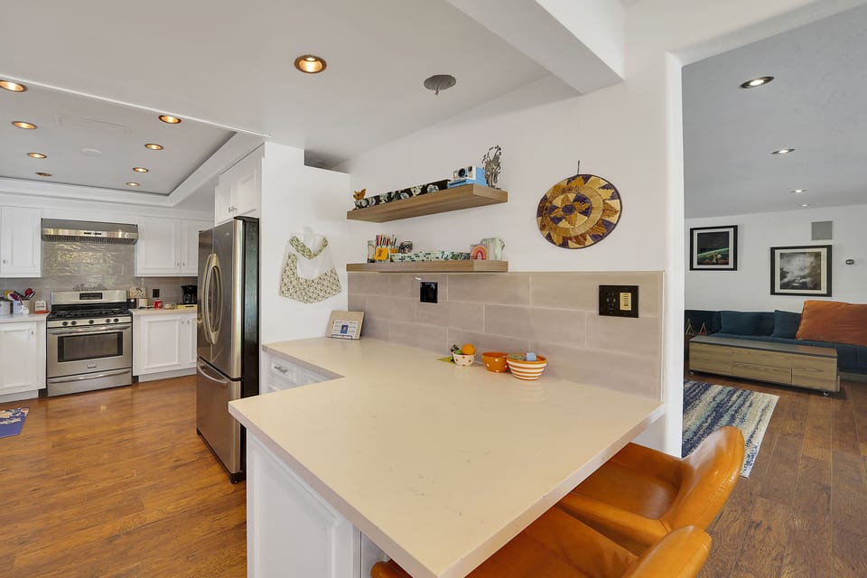Quartz counter tops stainless appliances and a gas stove.