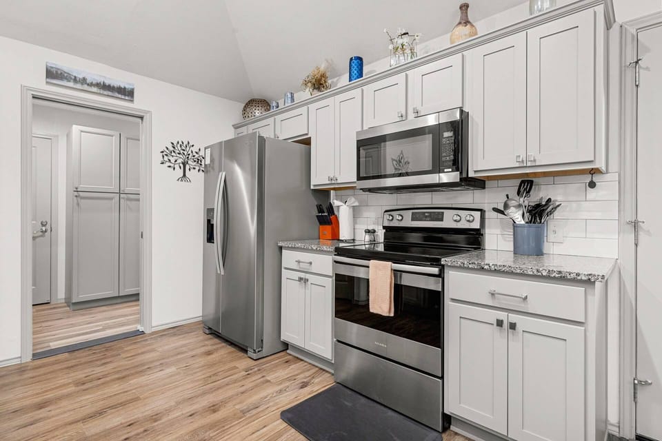 Cool gray cabinets, granite countertops, stainless-steel appliances, and full-sized pantry make for a chef's dream.