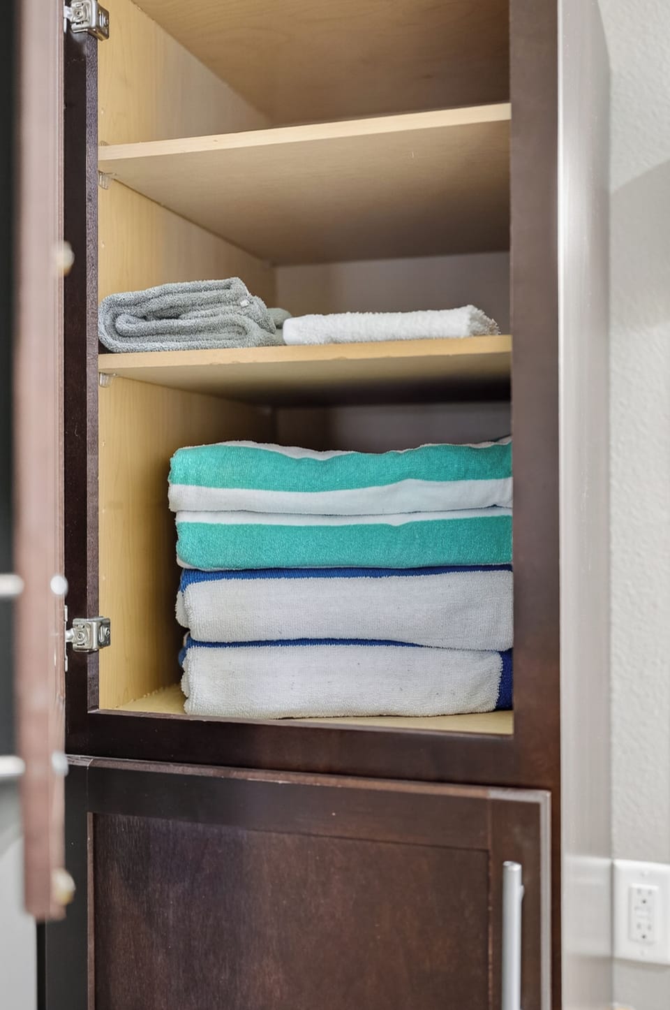 Neatly stocked linen cabinet with fresh towels for guest convenience
