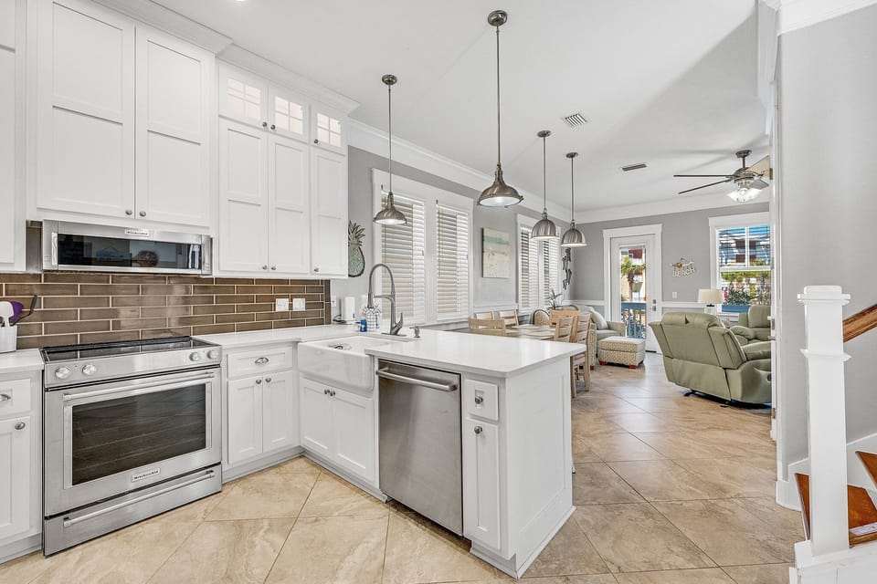 You'll love preparing meals in this bright, modern kitchen with sleek white cabinets, granite countertops, and stainless steel appliances flowing into your comfortable living space.