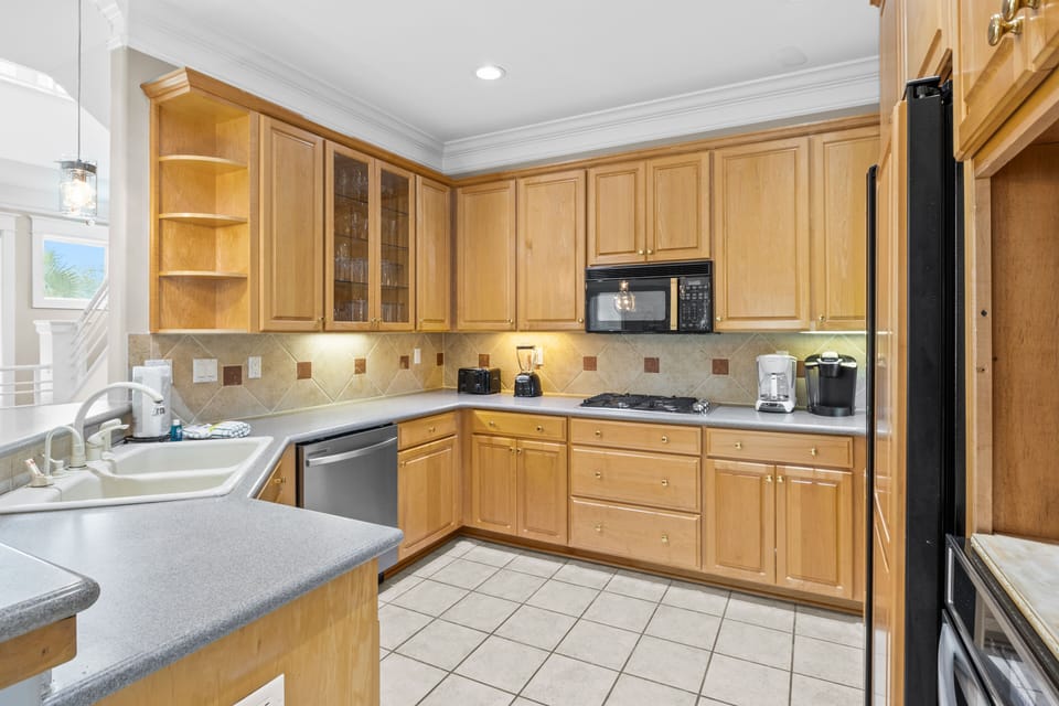 Your fully equipped kitchen features warm wood cabinets, granite countertops, and modern appliances—perfect for preparing memorable meals during your stay.