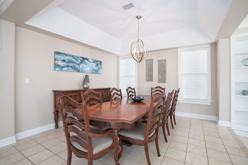 Gather around this elegant dining table for memorable meals together, with stylish artwork and warm lighting creating the perfect atmosphere.