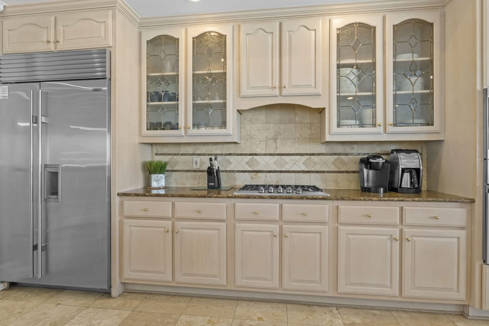 Your gourmet kitchen features granite counters, decorative glass cabinets, and premium appliances for culinary adventures.