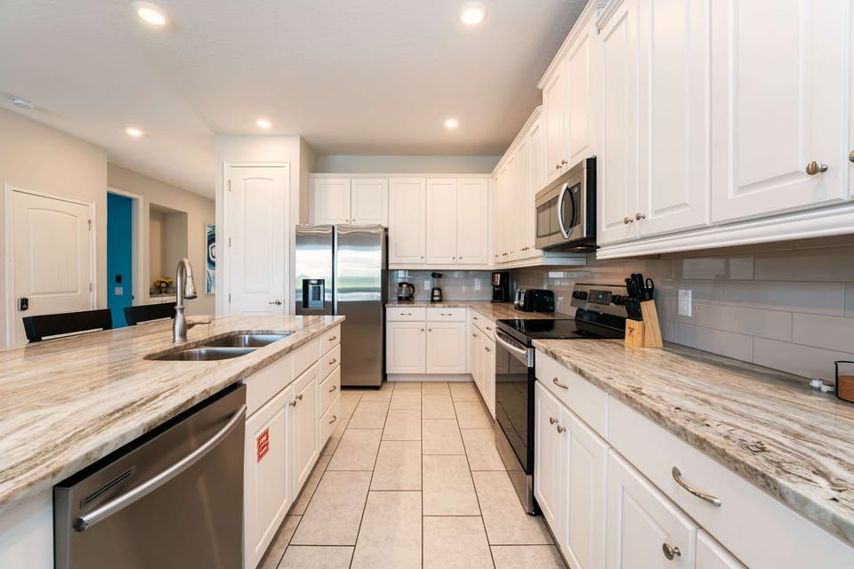 Elegant kitchen with sleek granite countertops and top-of-the-line stainless steel appliances, perfect for hosting and culinary creativity.