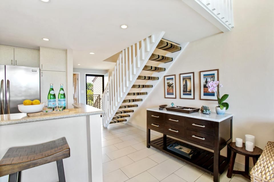 Enjoy cooking in this bright, modern kitchen with stainless steel appliances, sleek stone counters, and soft lighting   