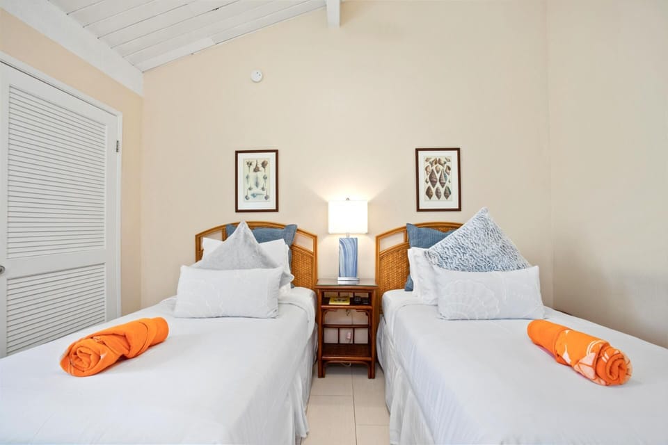 Chic twin suite with natural light, soft tones, wood accents, and a tranquil vibe for a rejuvenating island stay   