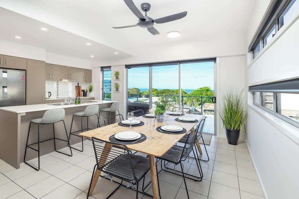 Large windows and open-plan living frame leafy outlooks and glimpses of the ocean, bringing the outdoors into every meal.
