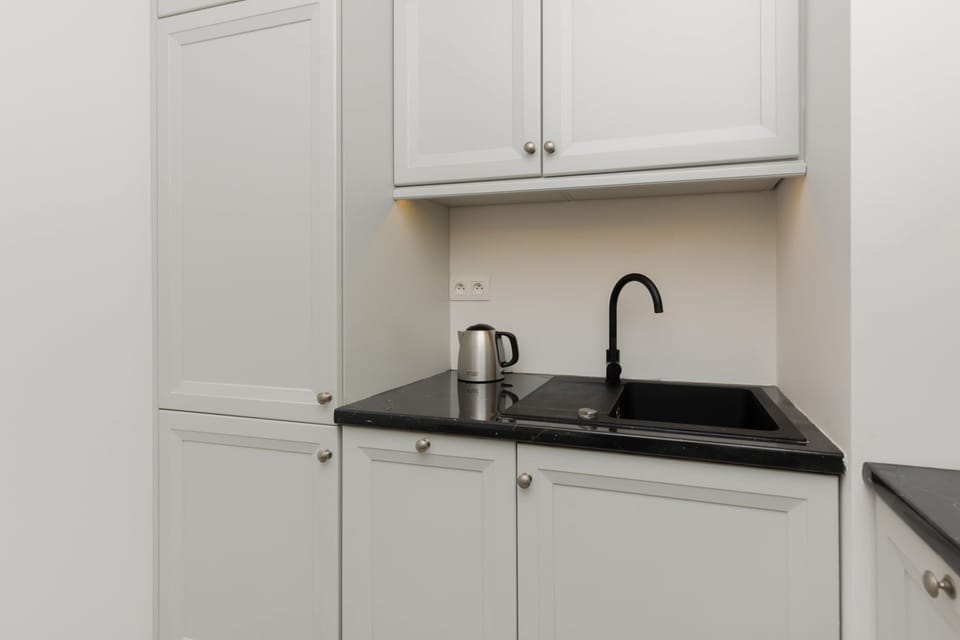 A close-up of the kitchen area, showcasing its clean, all-white cabinetry and modern design.