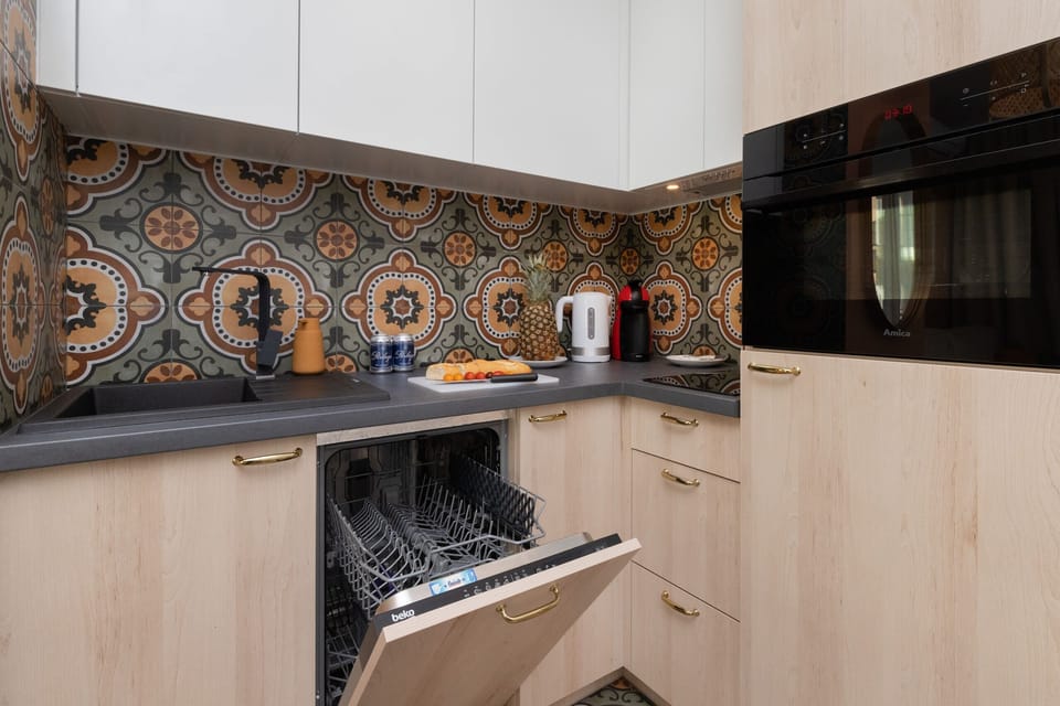 A well-equipped kitchen with wooden cabinets, a stove, and an eye-catching backsplash. The compact layout is both functional and aesthetically pleasing.