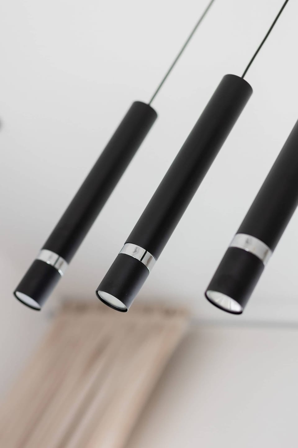 A close-up of pendant lights in a minimalist black design. These lights add elegance and modernity to the space.
