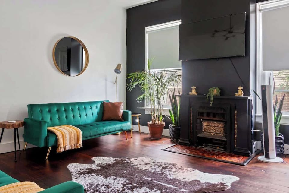 Discover the Charm of Our Jungle House Airbnb - Stylish Living Room with Modern Decor! Round Mirror & Gold Accents ️