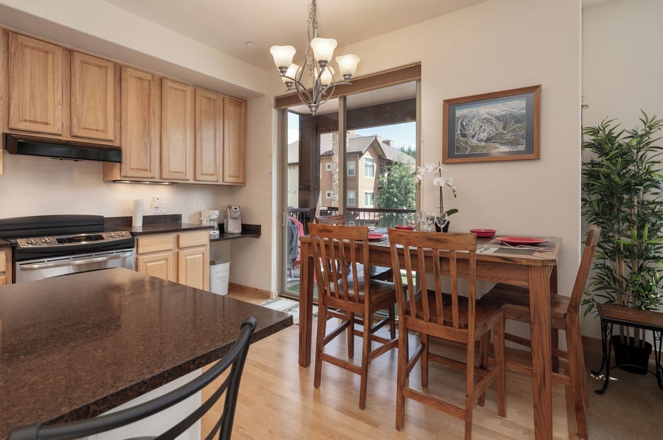 Your open kitchen flows into a warm dining space with mountain views, perfect for preparing meals and gathering together.