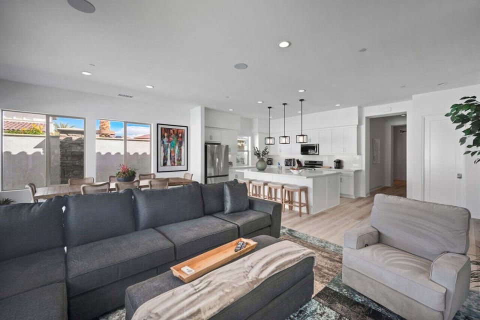 Open living area w/ sectional seating flowing into the kitchen & dining space