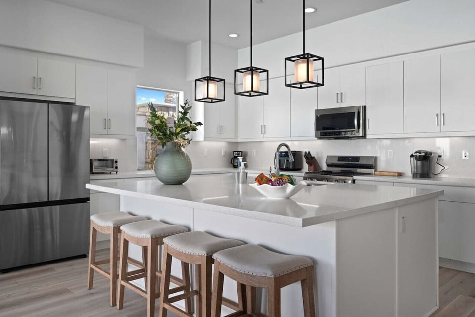 Sleek kitchen w/ large island, bar stools & pendant lighting for casual meals