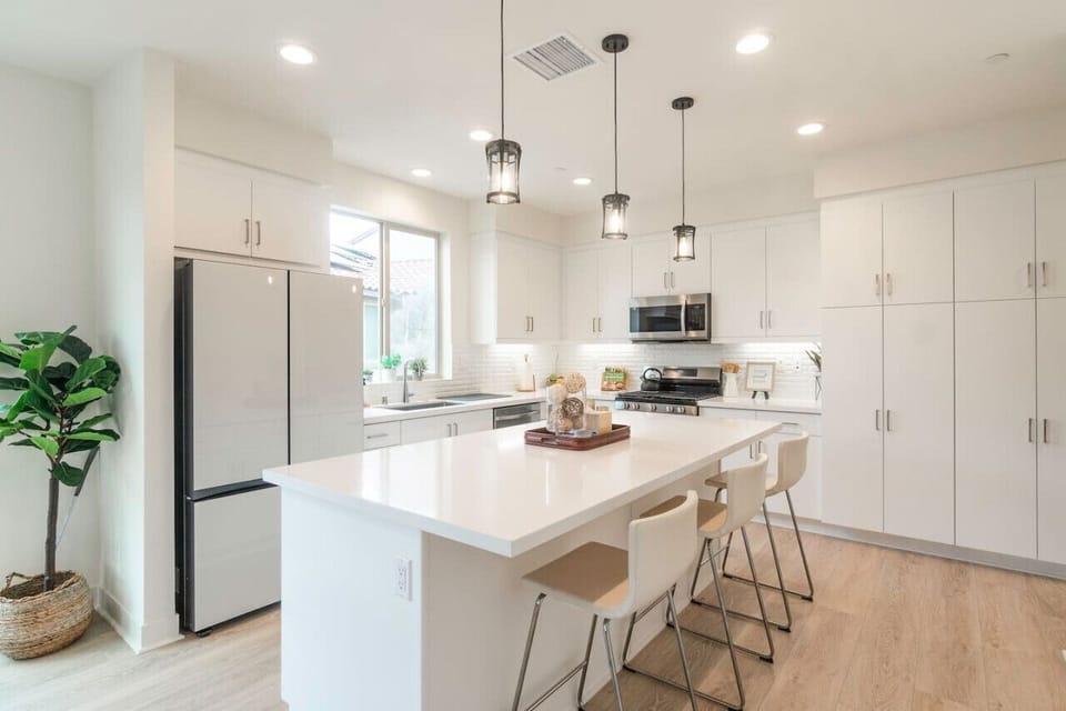 Sleek kitchen w/ stainless appliances, island seating & plenty of prep space