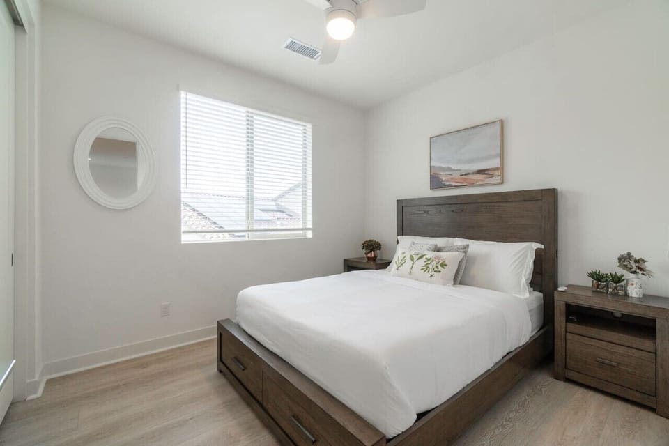Light-filled bedroom w/ wood furniture, soft textures & a peaceful vibe