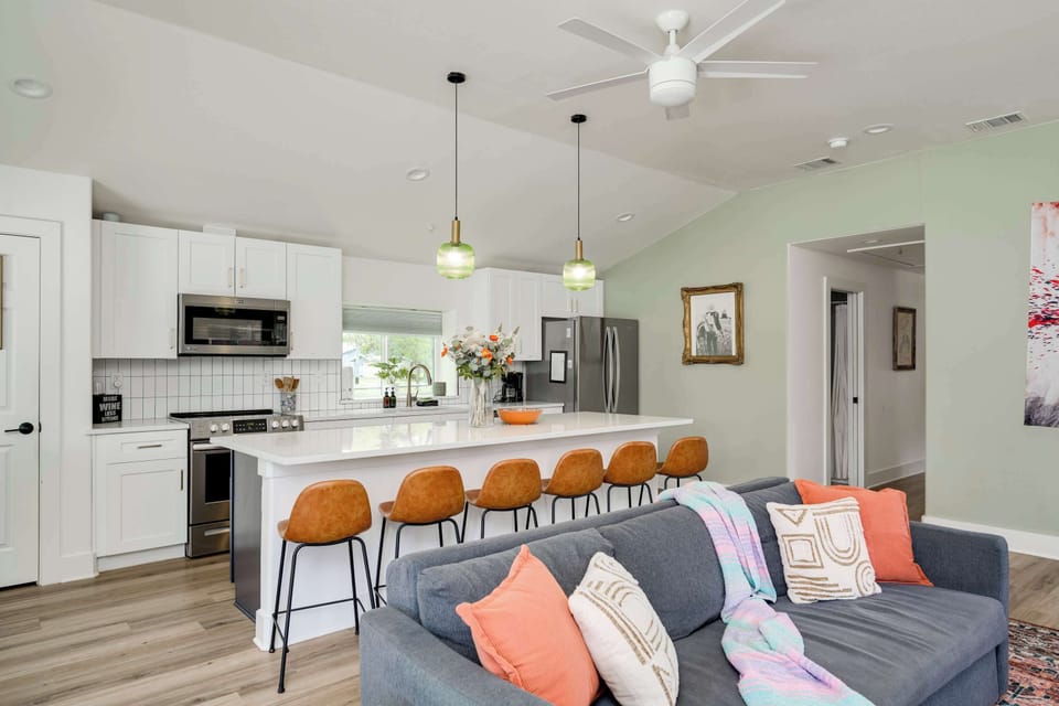 Living area with game table, open concept to kitchen and large entertainers island with backyard access. 