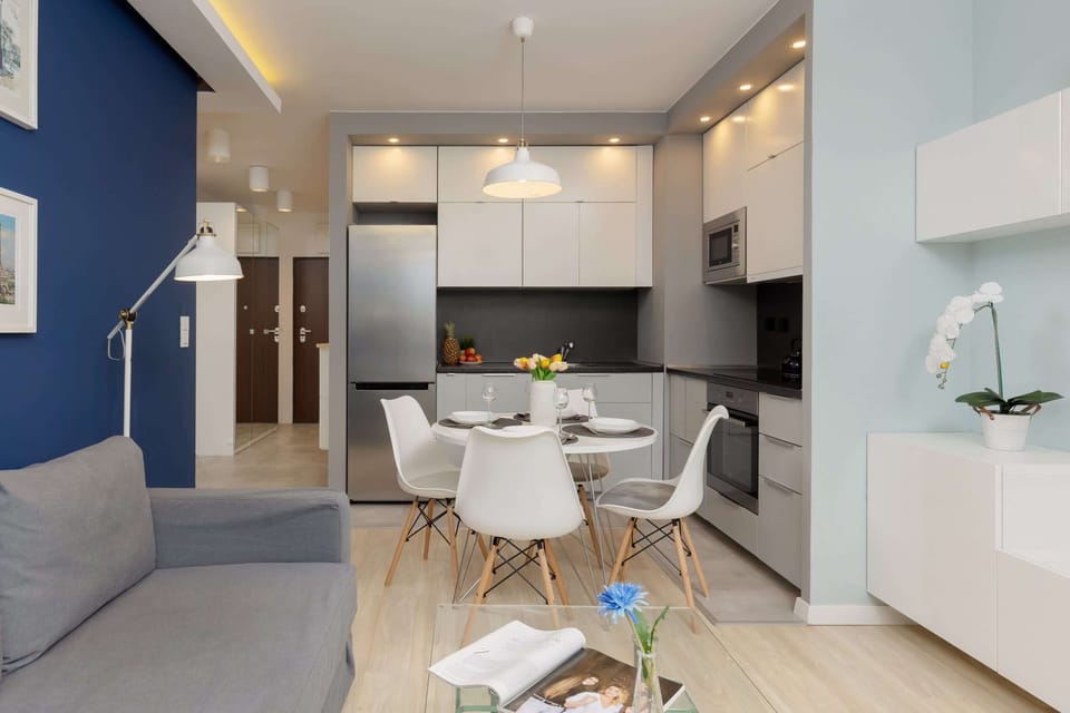 A cozy living area featuring a blue sofa, a glass coffee table, and elegant decor elements.