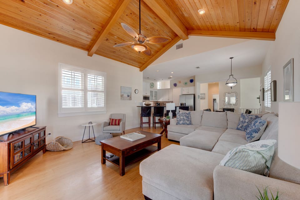 Relax in your spacious living room with soaring wood-beamed ceilings, plush sectional seating, and an open-concept design perfect for gathering.
