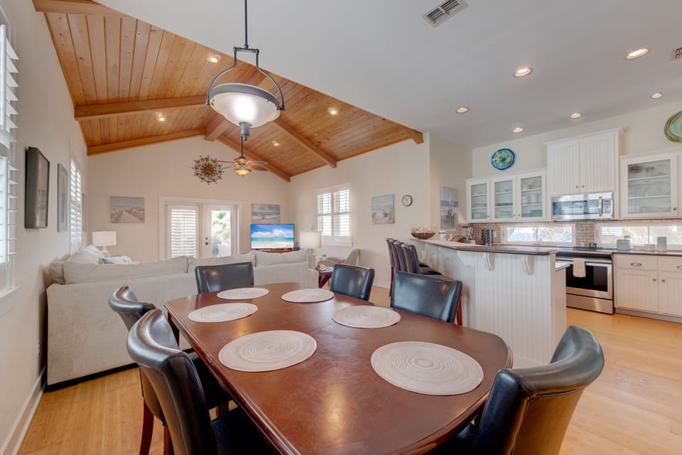 Your open-concept living space features soaring wood-beam ceilings and flows seamlessly from dining to kitchen, perfect for gathering with loved ones.