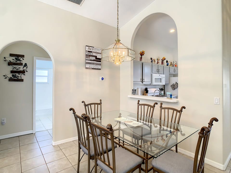 Elegant dining area with a glass-top table and stylish lighting.