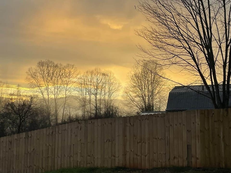 Experience the breathtaking allure of the sunset from our front porch, where a distant mountain silhouette meets the painted skies 