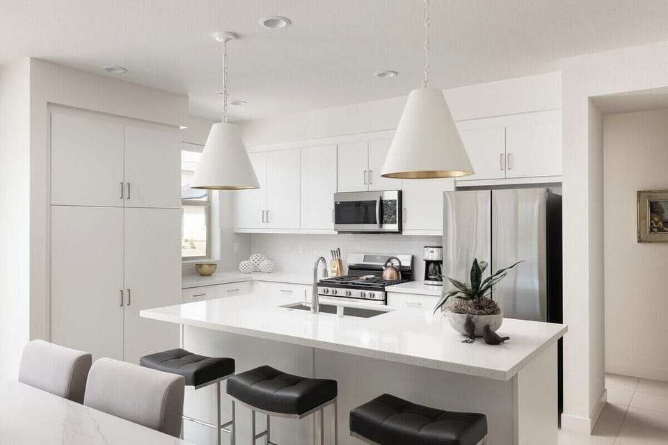 All-white modern kitchen with breakfast bar.