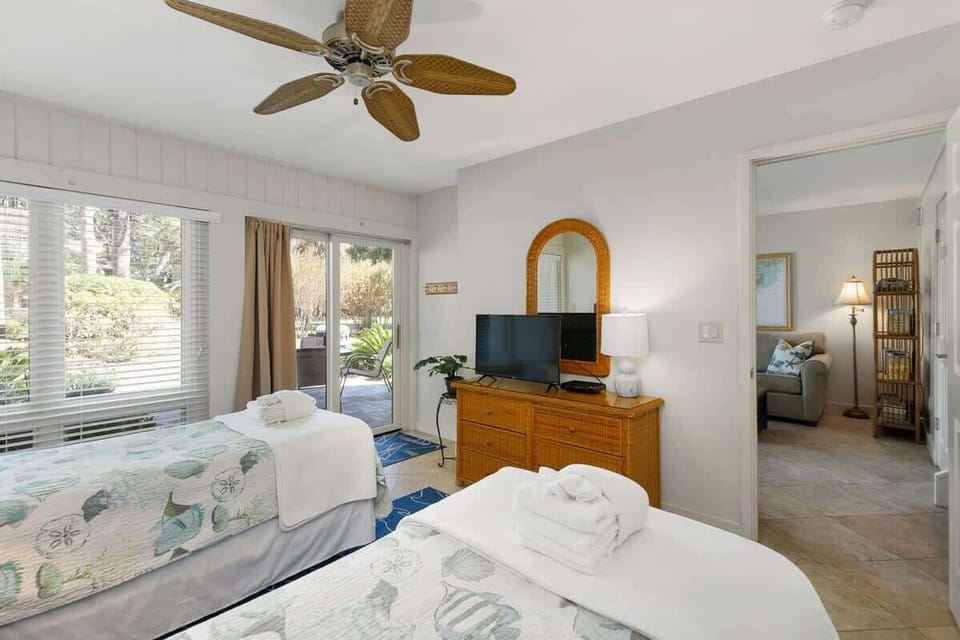Relax in your bright bedroom with tropical ceiling fan, garden views, and cozy twin beds perfect for peaceful sleep.