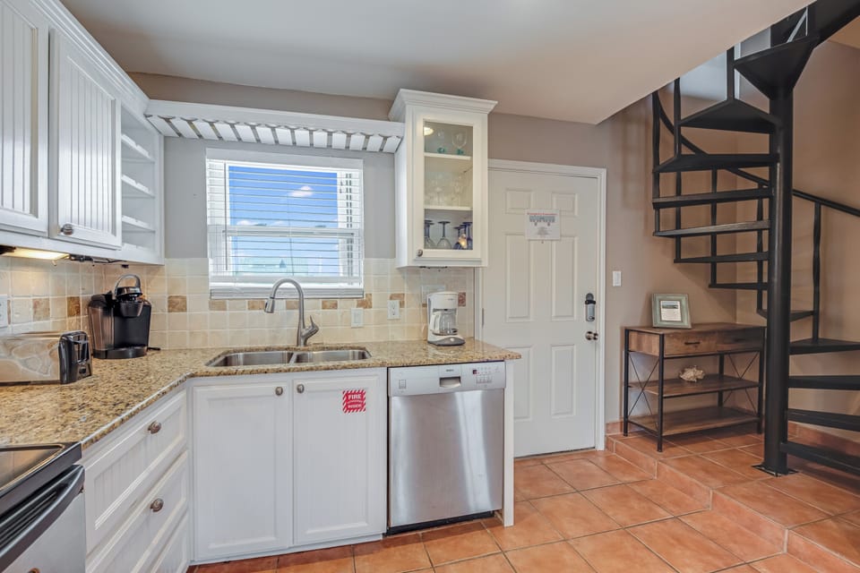 Your fully equipped kitchen features granite counters, stainless appliances, and charming spiral stairs leading to your private loft space.