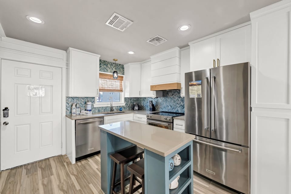 Your fully equipped kitchen invites culinary adventures with modern appliances, stylish herringbone tile, and a cozy island perfect for morning coffee.
