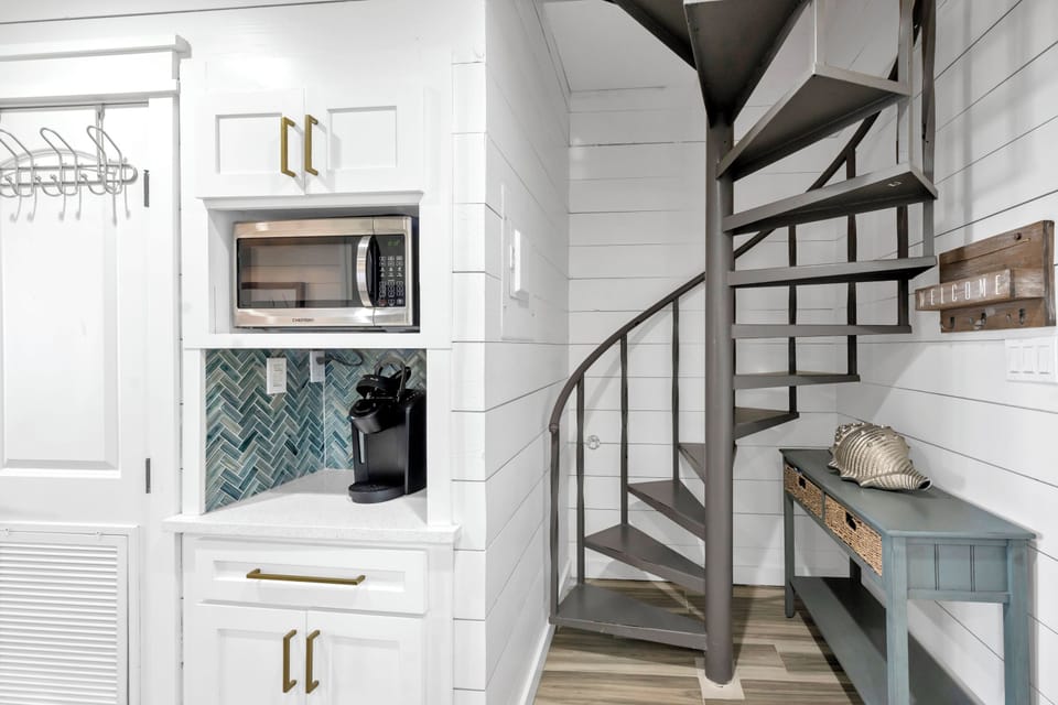 Your modern kitchen features sleek appliances and stunning tile backsplash, with charming spiral stairs leading to your cozy loft above.