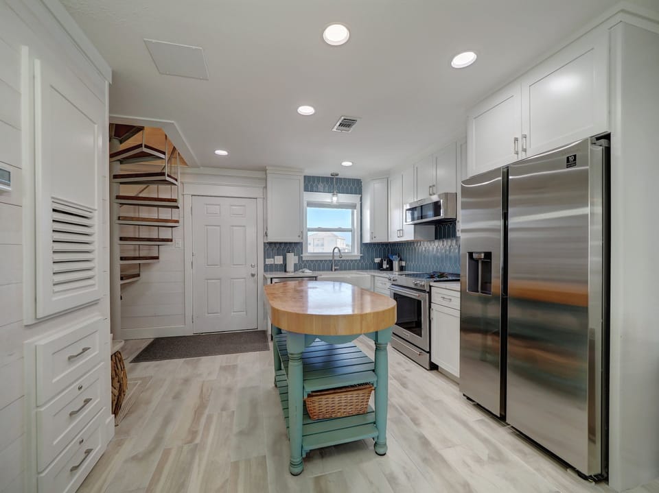 Your fully equipped kitchen features modern stainless appliances, ample prep space, and a charming island for meal preparation and casual dining.