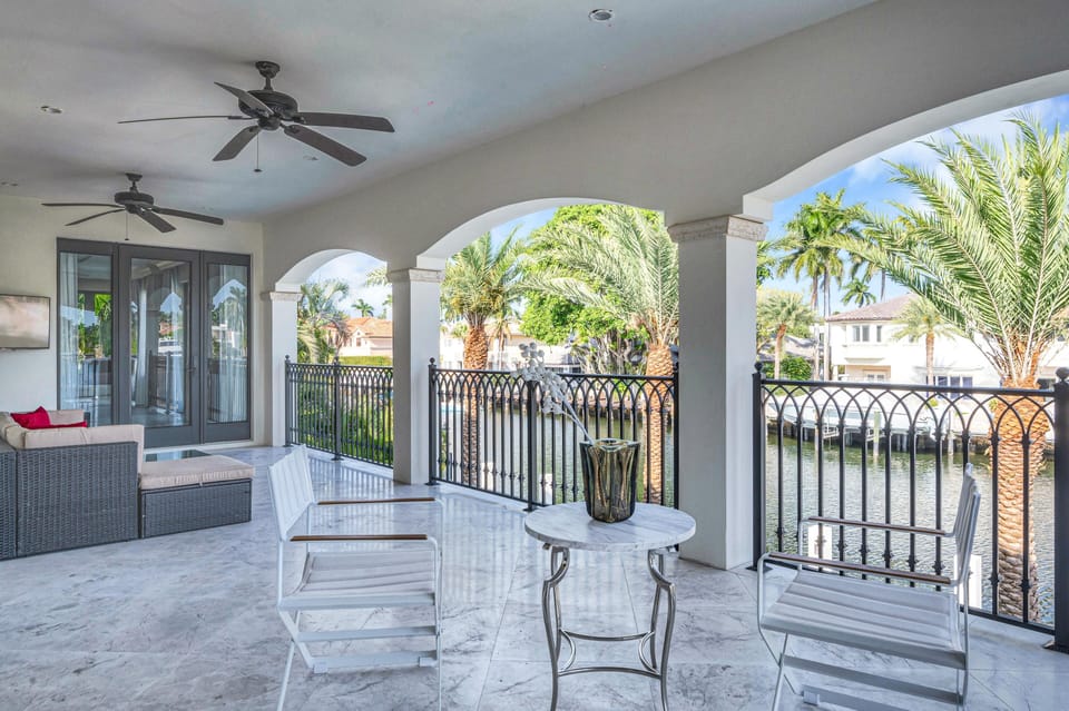 The balcony off the primary bedroom overlooking the canal features a lounge area with a TV.