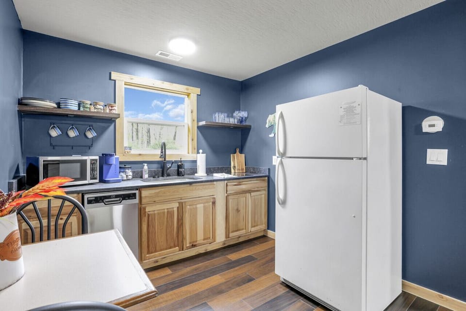 Kitchen table, dishwasher, microwave, coffee maker, sink, and fridge