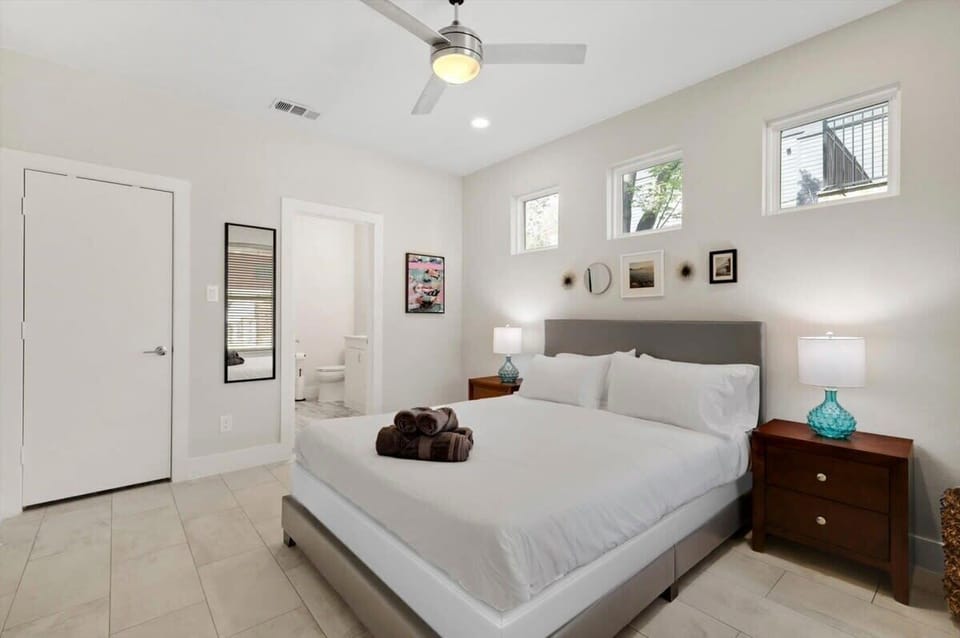 In this bedroom, the plush comfortable bed takes center stage; adorned with soft, cozy linens, it will invite you to sink in and drift off to sleep amidst sweet dreams.