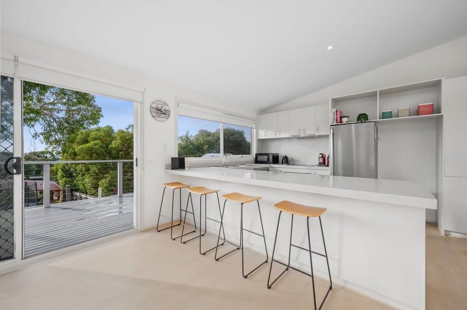 The kitchen features stainless appliances and a breakfast bar, designed for both functionality and style
