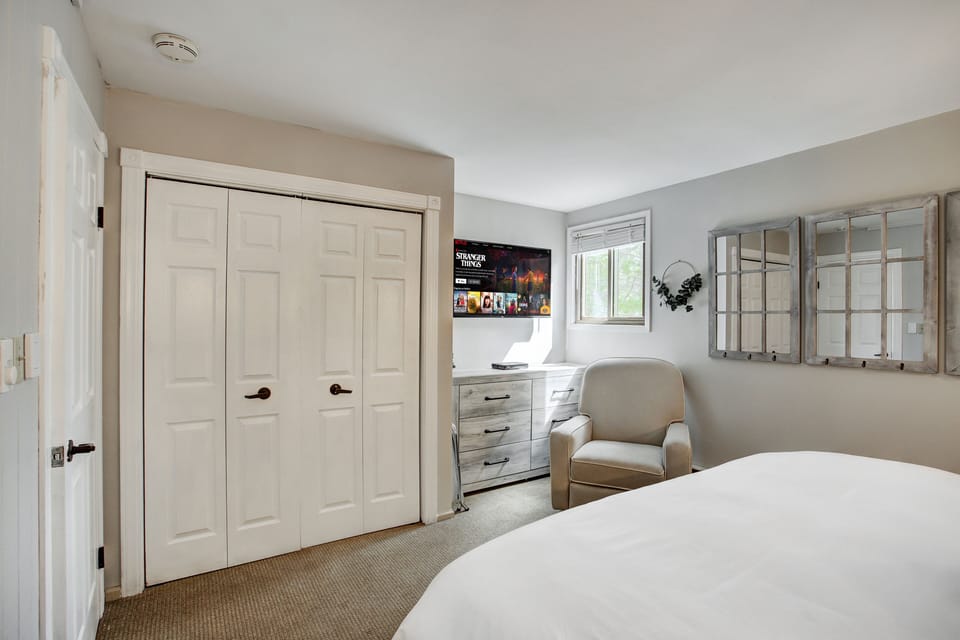 Cozy bed with TV and large closet for storage.