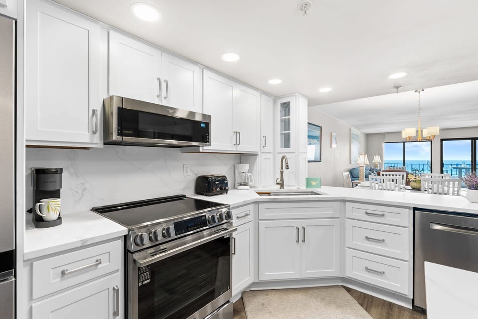 Kitchen - Modern kitchen featuring marble countertops, a spacious island, and updated stainless steel appliances.