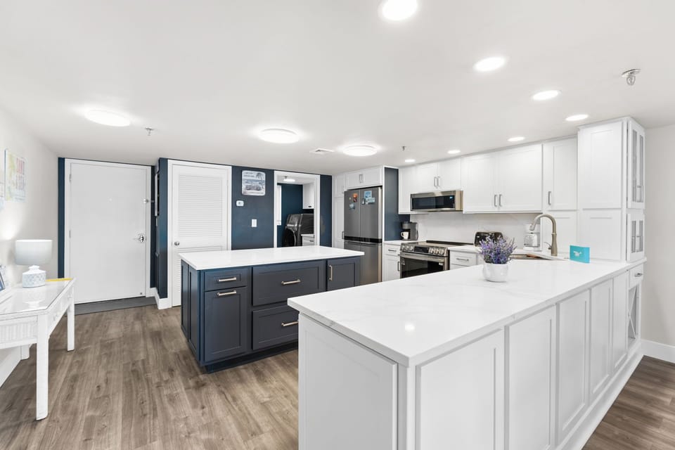 Kitchen - Bright, updated kitchen with elegant marble surfaces and an island for gathering.