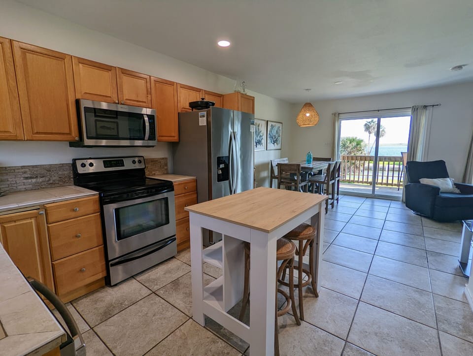 Cook your favorite meals in this fully equipped kitchen with stainless steel appliances, then enjoy them at the island breakfast bar.