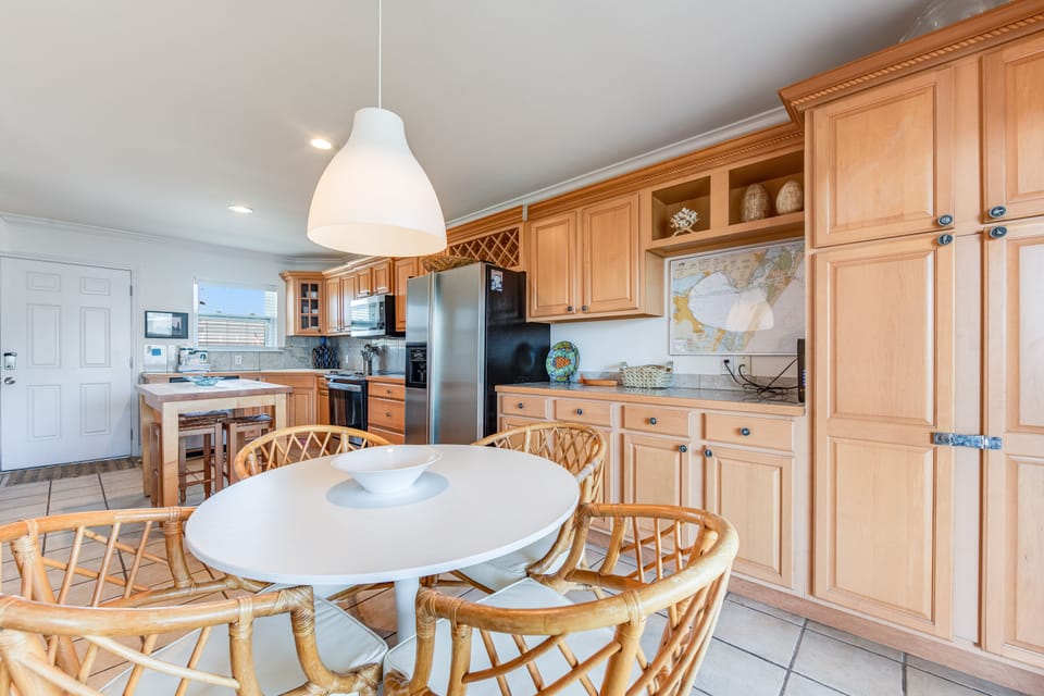 Your spacious kitchen and dining area invites memorable meals with warm wood cabinetry, modern appliances, and cozy seating for eight.