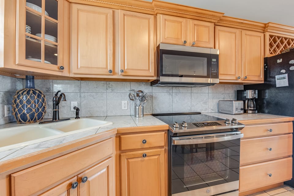 Your fully equipped kitchen features warm maple cabinets, granite counters, and modern appliances for memorable meal preparation.
