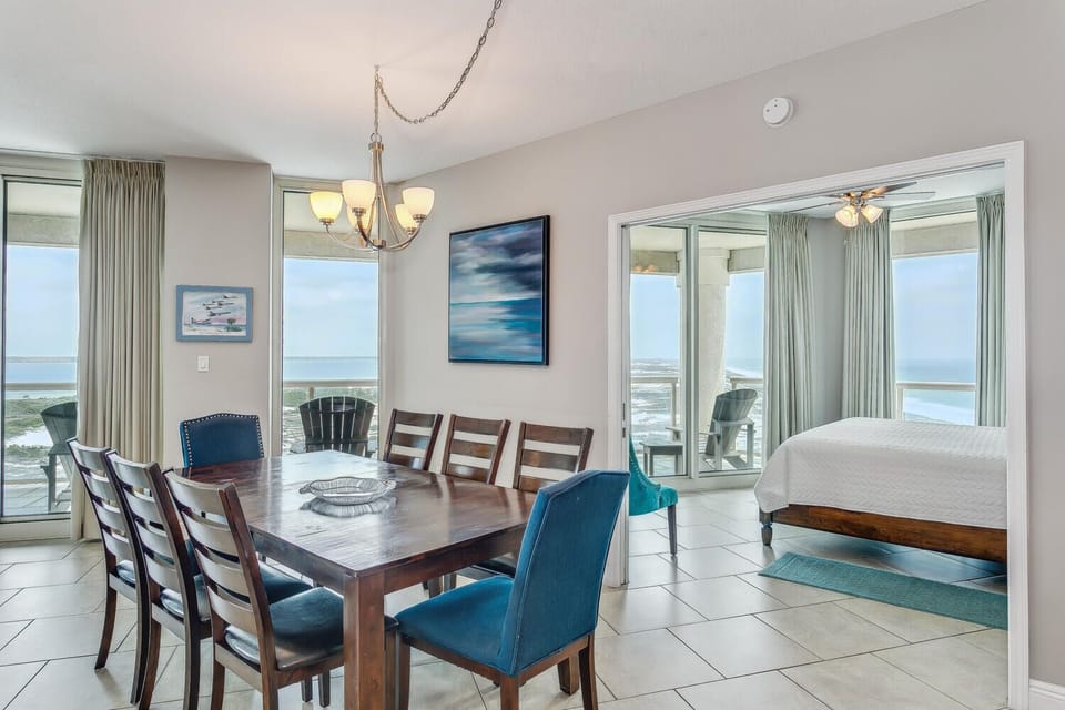 Gather around the spacious dining table for meals with a view. Floor-to-ceiling windows frame the sparkling ocean, while soft coastal tones and modern touches create a serene, inviting atmosphere perfect for making memories together.