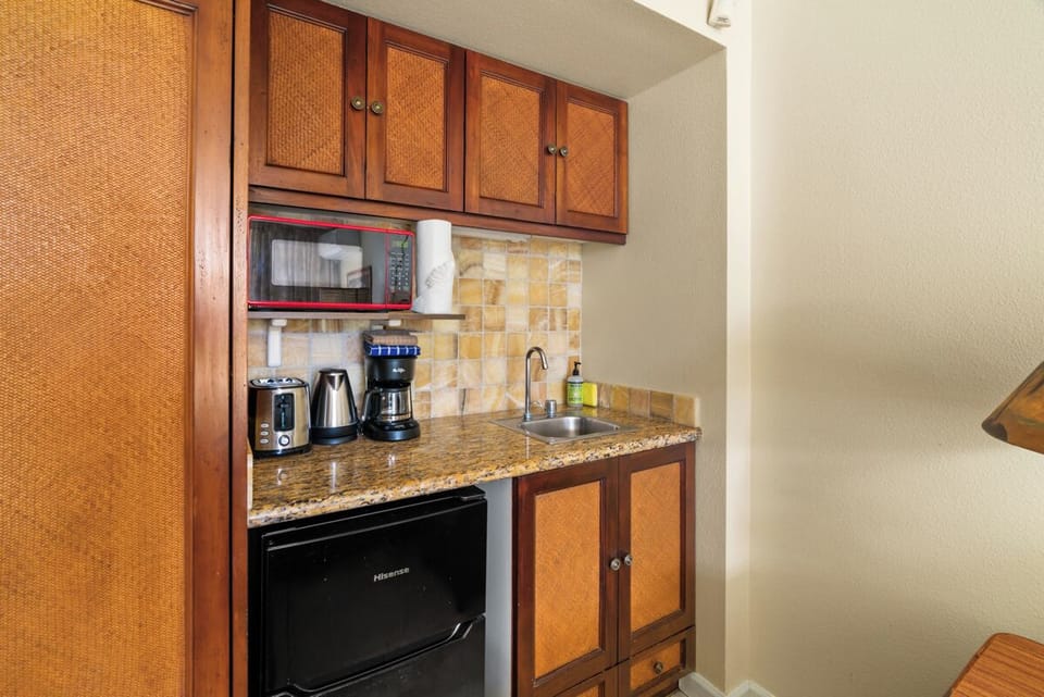 Kitchenette with undercounter refrigerator, microwave, toaster and coffee maker.