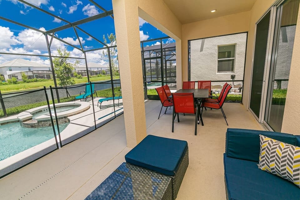 Covered patio with outdoor dining and seating, looking out to the private pool.