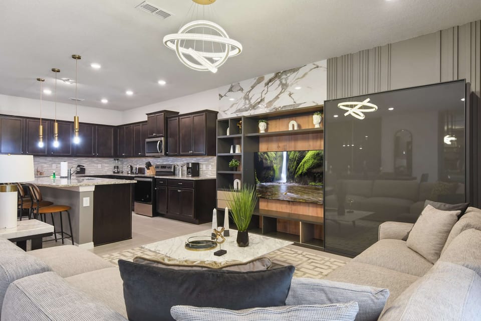 Spacious open-plan living, dining, and kitchen area with modern decor and seating.