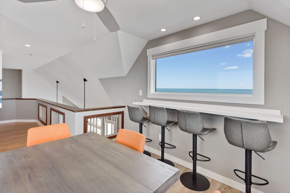 Beginning on the Top Level of this gorgeous home, you'll find a spacious Loft with a leaning bar overlooking the sound, additional dining area space, and a desk area.