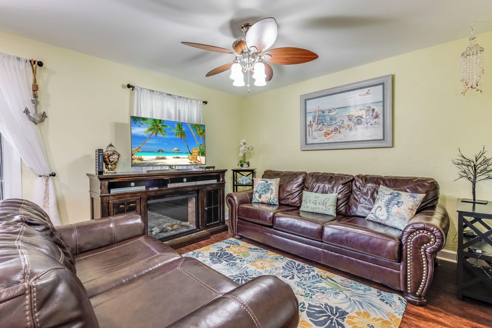 Sink into plush leather seating while enjoying your favorite shows on the large TV in this cozy living room designed for relaxation.