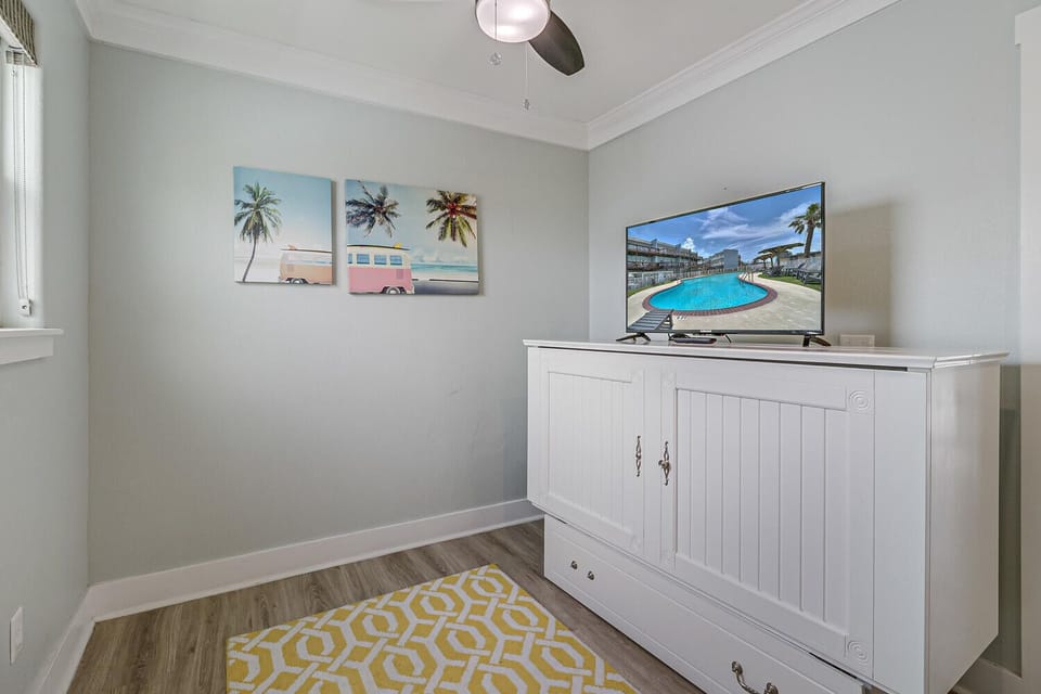 Unwind in your entertainment space with tropical artwork and modern TV on coastal-style storage.
